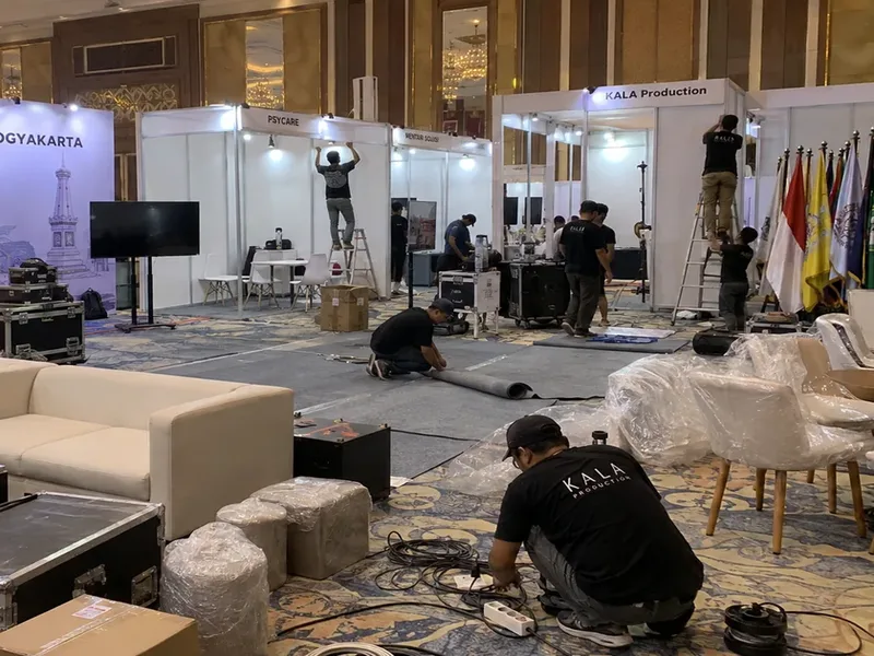 Deretan bilik stand booth partisi R8 Octanorm siap pakai lengkap dengan fascia board nama tenant, lampu spotlight, meja, dan kursi di ballroom